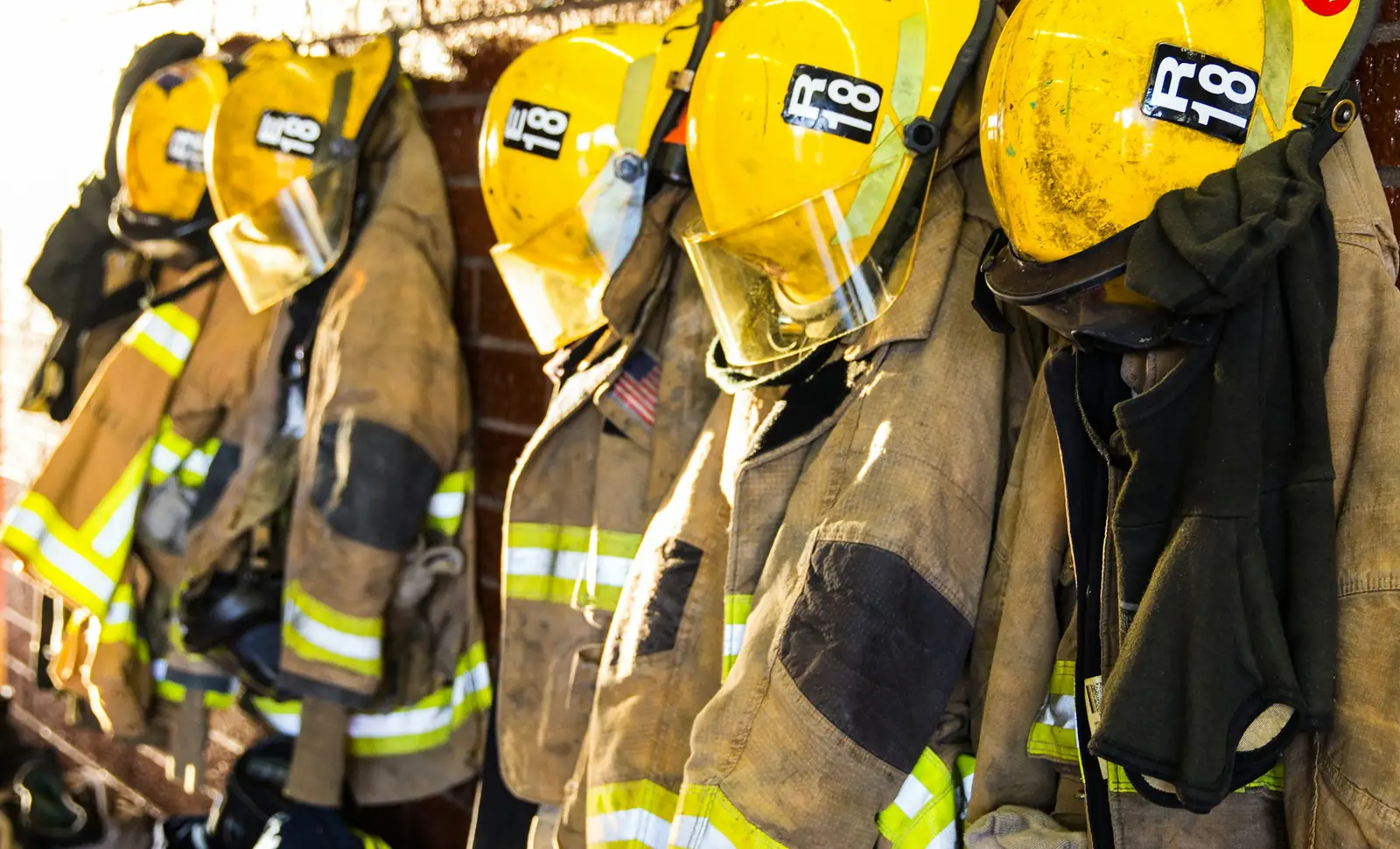 Firefighter turnout coats and helmets hanging at a fire station